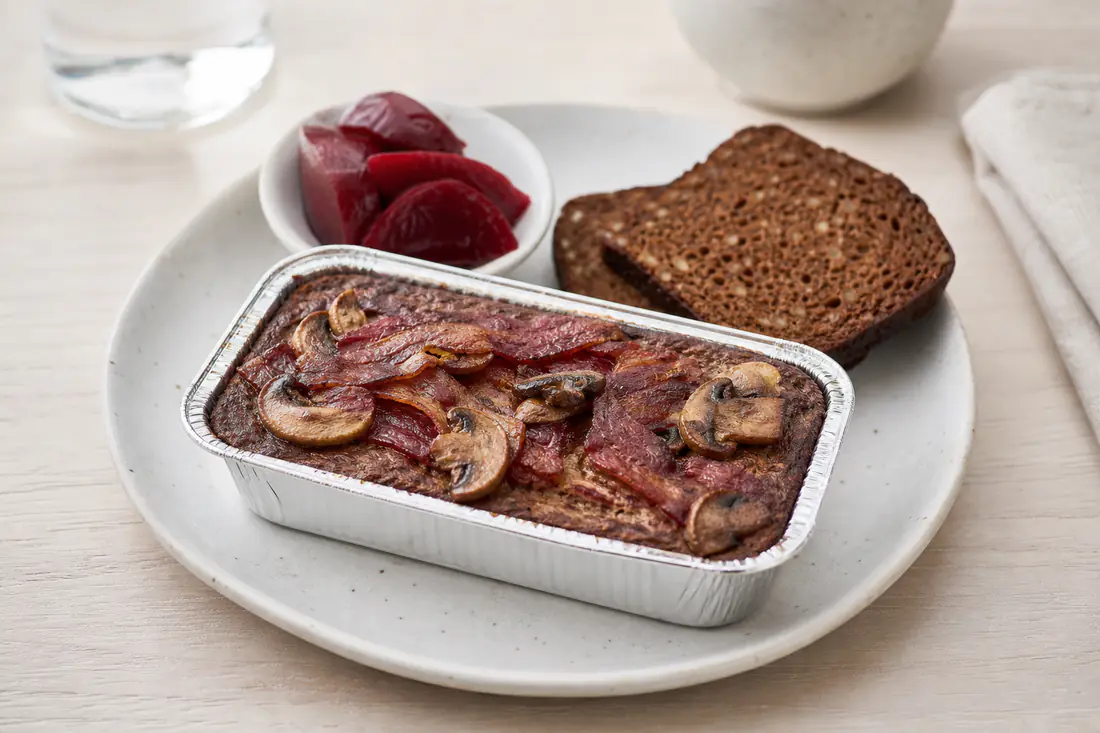 Lun leverpostej i alubakke toppet med sprød bacon og stegte champignoner, serveret med rugbrød og rødbeder