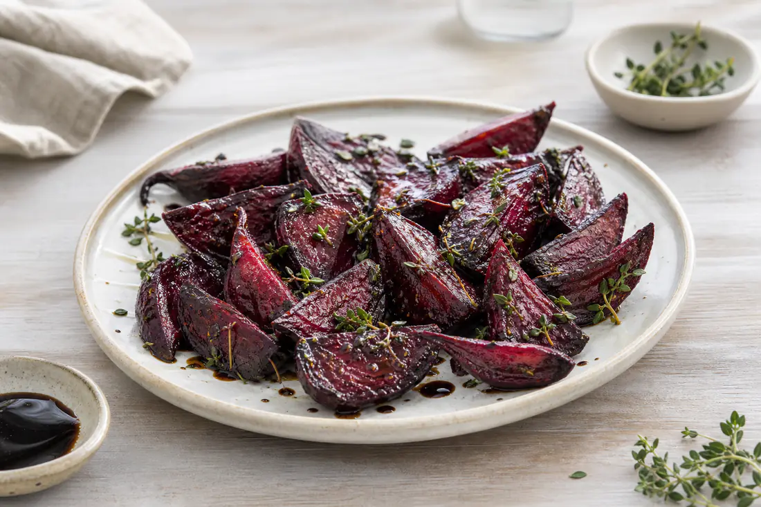 Bagte rødbedebåde med timian og dryp af balsamico på en lys tallerken